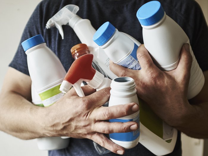 Man holding empty plastic bottles and containers for recycling